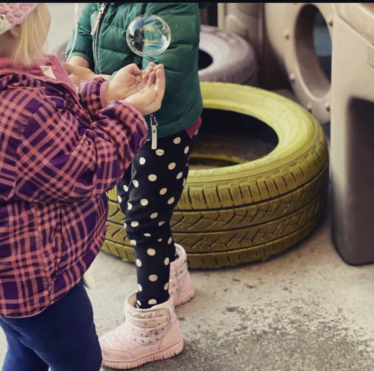 Kids catching bubbles outside on a chilly morning