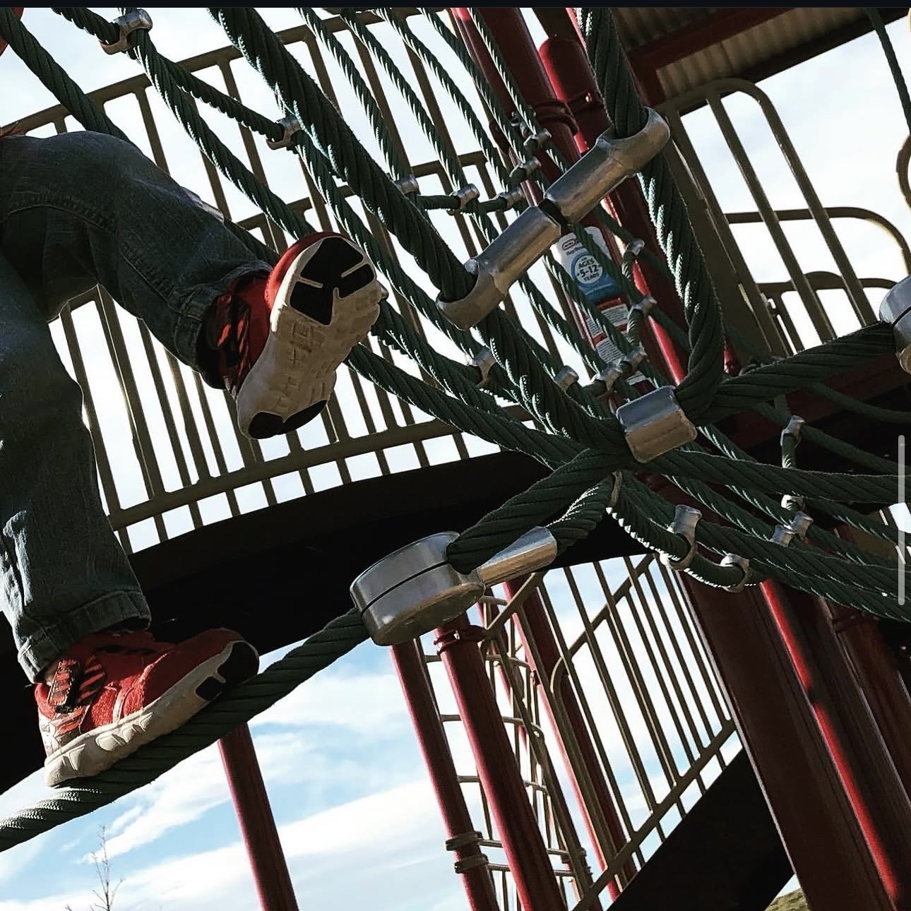 Climbing a rope playground structure